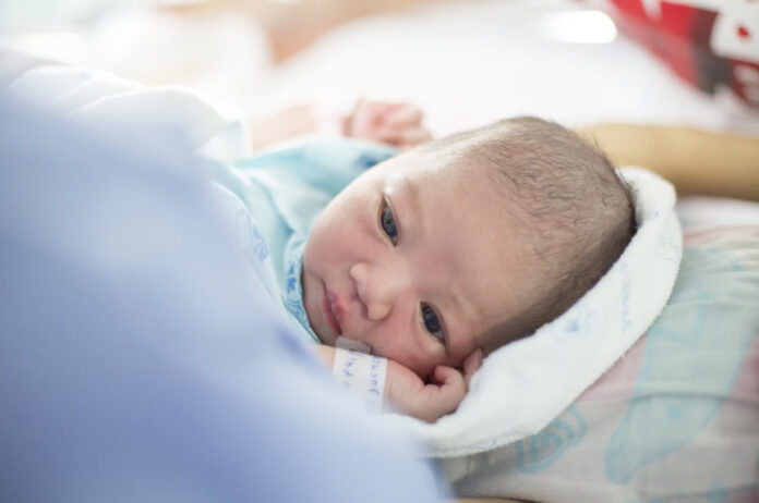 new born infant asleep in the in hospital room